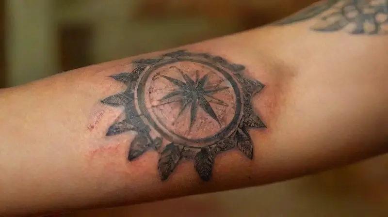 Close-up of tattooed arm with piercings