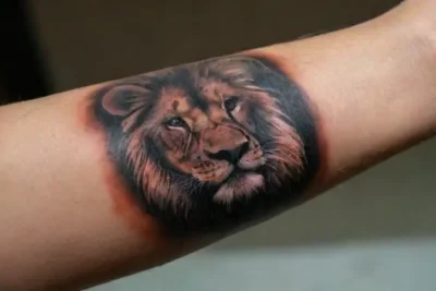 Close-up of realistic lion tattoo on forearm