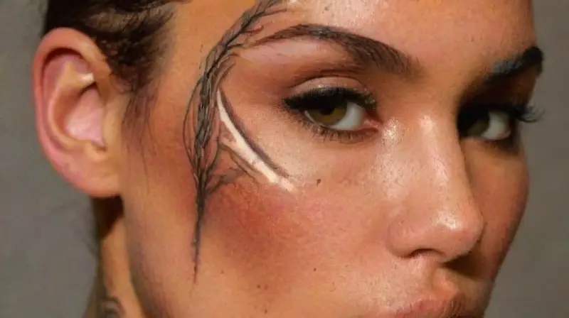 Persons detailed tattoos and natural features highlighted