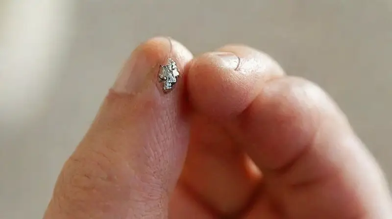 Close-up of hand holding a metallic piercing