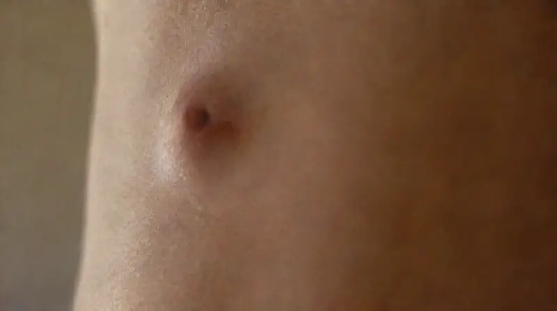Detailed close-up of pierced abdomen skin